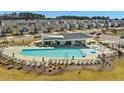 Resort-style community pool with chairs, umbrellas, and a modern pool house overlooking the area at 1091 Channel Drop Lp, Zebulon, NC 27597