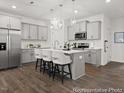Modern kitchen featuring an island with seating, stainless steel appliances, pendant lighting and grey cabinets at 115 N District Ave # 298, Clayton, NC 27527