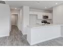 Bright kitchen featuring an island with marbled countertop and modern appliances at 124 Landon Pl, Roxboro, NC 27573