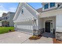Close up of a two car garage and entry to the home showcasing stone accents and a walkway at 1306 Cricket St, Elon, NC 27244