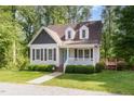 Charming home with manicured front lawn and inviting front porch in a serene, wooded setting at 200 Weybossett Rd, Henderson, NC 27537