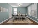 Well-lit dining room with a dark wood table, six chairs, and neutral-toned decor creating an inviting atmosphere at 212 Crisp Rd, Durham, NC 27713