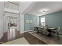 Inviting dining room featuring wood floors, modern lighting, and a view into a spacious living area at 212 Crisp Rd, Durham, NC 27713