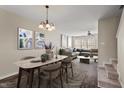 Open-concept dining area with modern lighting and elegant table, flowing into the living room at 235 Michigan Ave, Cary, NC 27519
