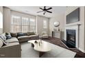 Bright living room featuring hardwood floors, modern ceiling fan and a cozy fireplace at 235 Michigan Ave, Cary, NC 27519