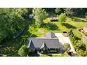 Aerial view of a brick home with mature trees, a garden and a driveway at 2457 Millbrook Dr, Haw River, NC 27258