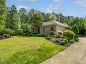 Home featuring lush green lawn, beautiful landscaping, and a classic brick exterior at 280 Dreamcatcher Trl, Youngsville, NC 27596