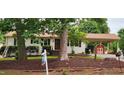 Charming single story home with white painted brick and a covered parking area with a red storage shed at 2917 Trail Six, Burlington, NC 27215
