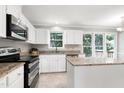 This spacious kitchen has white cabinets, stainless steel appliances, granite counters, and a kitchen island at 300 Silvercliff Trl, Cary, NC 27513