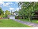 This home boasts a well-manicured lawn and a convenient two-car garage, set amidst lush, mature trees at 3209 Marie Dr, Raleigh, NC 27604