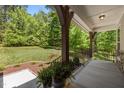 Relaxing front porch with views of a lush green lawn and mature trees, ideal for enjoying the outdoors at 3425 Donnigale Ave, Durham, NC 27705