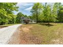 View of a charming gray home nestled within a lush, green landscape at 35 Fire Tower Dr, Rougemont, NC 27572