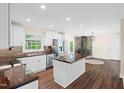 Bright kitchen featuring white cabinets, stainless steel appliances, island, and wood floors at 35 Fire Tower Dr, Rougemont, NC 27572