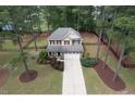 Aerial view of a two-story house with a manicured lawn, driveway, and surrounding trees at 35 Pine Water Way, Spring Lake, NC 28390