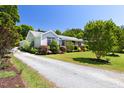 View of the exterior of the home showing the well-maintained gravel driveway and lush landscaping at 416 Mitchell St, Hillsborough, NC 27278