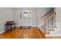 Bright foyer featuring hardwood floors, a staircase, and a white front door with decorative glass panels at 4589 Freedom Dr, Burlington, NC 27215