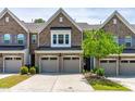 Charming brick townhome with a two-car garage, manicured lawn, and a well-maintained landscape at 525 Durants Neck Ln, Morrisville, NC 27560