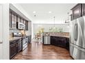 Beautiful open kitchen with stainless steel appliances, granite countertops and dark wood cabinetry at 525 Durants Neck Ln, Morrisville, NC 27560