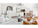 Open-concept living room showcasing hardwood floors, a staircase, a kitchen bar, and a dining area with abundant natural light at 525 Durants Neck Ln, Morrisville, NC 27560