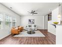 Bright and airy living room with multiple windows, ceiling fan, hardwood flooring, and modern furnishings at 525 Durants Neck Ln, Morrisville, NC 27560