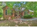 Picturesque brick home with mature trees, arched window, and a cozy front porch at 5524 Jomali Dr, Durham, NC 27705