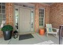 Welcoming front porch area featuring a neutral door, cozy seating, and brick accents at 5524 Jomali Dr, Durham, NC 27705