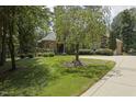 Charming stone house with mature tree, lush green lawn, and large circular driveway at 5901 Charleycote Dr, Raleigh, NC 27614