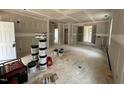 Unfinished living room with drywall, paint supplies, and an open floor plan, awaiting your personal touch at 604 Natchez Trace, Fuquay Varina, NC 27526