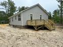 New home exterior featuring a wooden deck with stairs and light gray siding at 604 Natchez Trace, Fuquay Varina, NC 27526