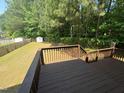View from wood deck overlooking a spacious, green backyard with a wooden fence and plenty of trees at 607 Wahlbrink Dr, Wake Forest, NC 27587