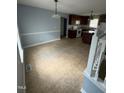 Dining room featuring tile floors and access to the kitchen with an island and dark wood cabinets at 607 Wahlbrink Dr, Wake Forest, NC 27587