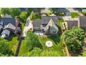 An aerial view of a home with a backyard featuring a patio and stone fire pit at 608 Driftwood Dr, Gibsonville, NC 27249