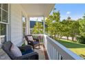 Cozy porch with wicker chairs, plush cushions, and a view of the lush, green lawn and mature trees at 612 Lakeview Ave, Wake Forest, NC 27587