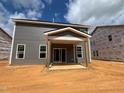Back of house with covered patio under construction, showing sliding glass doors and yard space at 776 Old Station Pointe, Angier, NC 27501