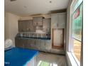 Kitchen with unfinished floors and grey cabinets with hardware, protected with plastic, and a window at 776 Old Station Pointe, Angier, NC 27501
