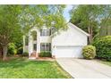 Charming two-story home with white siding, black shutters, landscaped yard, and attached two-car garage at 8814 Waynick Dr, Raleigh, NC 27617