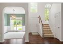 Foyer with hardwood floors, staircase, dining room with a hanging light fixture, and high ceilings at 8814 Waynick Dr, Raleigh, NC 27617