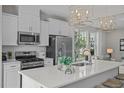 Bright kitchen features white cabinets, stainless appliances, tile backsplash and island with seating at 908 Kensley Grove Ln # 69, Fuquay Varina, NC 27526