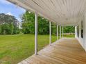 Inviting covered front porch featuring a wood deck with scenic views at 9652 S Nc-87 Hwy, Graham, NC 27253