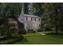 Charming two-story home with manicured lawn, blue door, black shutters, and mature trees at 1008 Winona Rd, Raleigh, NC 27609