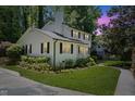Well-maintained two-story home with green lawn, mature trees, and lovely landscaping at 1008 Winona Rd, Raleigh, NC 27609