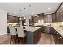Spacious kitchen with a large center island, granite countertops, and dark wood cabinetry at 1046 Covered Bridge Trl, Chapel Hill, NC 27517