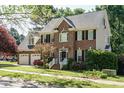 Charming brick two-story home with a two-car garage, black shutters, and well-maintained landscaping at 105 Kenmont Dr, Holly Springs, NC 27540