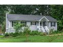 Exterior view of a charming single story home with gray siding, black shutters and a well-maintained lawn at 106 Palomino Cv, Louisburg, NC 27549