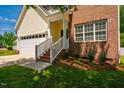 This home features brick accents, a well-manicured lawn, and an inviting entrance with brick steps and white railings at 11 Piccadilly Ct, Durham, NC 27713