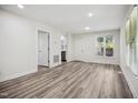 Inviting living room with luxury vinyl plank flooring, bright natural light, and white walls at 112 Carmichael Ct, Cary, NC 27511
