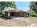 Exterior rear view showcasing a brick facade with a carport and a spacious lot at 11234 Nc Hwy 50, Benson, NC 27504