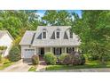 Inviting home showcasing a covered porch, dormer windows, an attached garage, and manicured landscaping at 116 Weaver Mine Trl, Chapel Hill, NC 27517