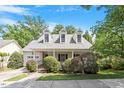 Beautiful home with a cozy front porch, dormer windows, an attached garage, and verdant landscaping at 116 Weaver Mine Trl, Chapel Hill, NC 27517