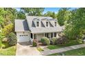 This lovely home features dormer windows, an attached garage, a covered porch, and mature trees at 116 Weaver Mine Trl, Chapel Hill, NC 27517